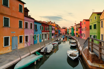 Fototapeta na wymiar Old colorful houses and boats at sunset in Burano, Venice Italy