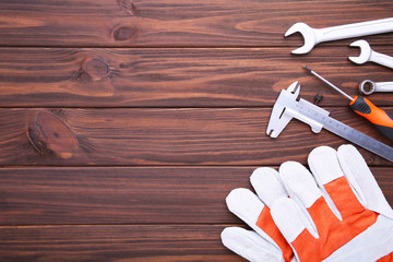 Different construction tools on brown wooden background with copy space.