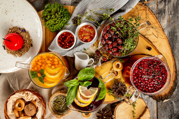 Top view image of various tea pots group at decorated with bakery and jam rural table background.