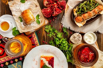 Top view image of traditional georgian lunch with various meals and ingredients at decorated wooden table background.