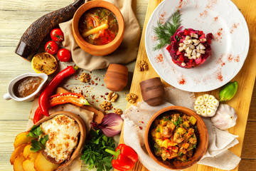 Top view image of traditional georgian lunch with various meals and ingredients at decorated table background.