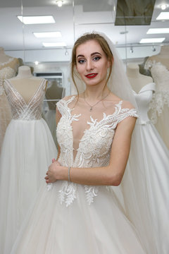 Woman fitting wedding dress and veil in shop