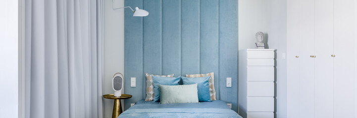 Bedroom with blue upholstered wall