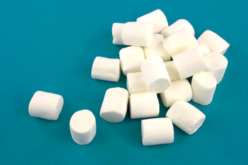 Fototapeta na wymiar Mini marshmallows on a blue background. geometric pattern of white marshmallows.