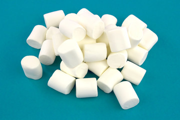 Mini  marshmallows on a blue background. geometric pattern of white marshmallows.