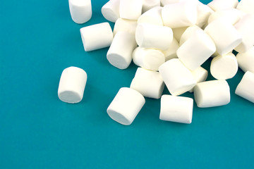 Fototapeta na wymiar Mini marshmallows on a blue background. geometric pattern of white marshmallows.