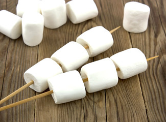 Fototapeta na wymiar Fluffy white marshmallow on old wooden table