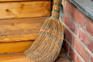 Old broom on the threshold of the house. Close up. Soft focus.