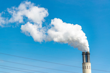 Großer Industrie Schornstein stößt Rauch aus.