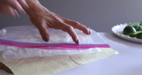 Hands crushing ice in plastic bag with a hammer - Powered by Adobe