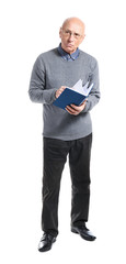 Fototapeta premium Portrait of elderly man with book on white background