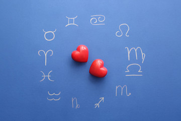 Zodiac signs and red hearts on color background. Love horoscope concept