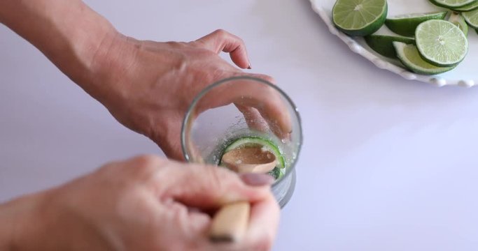 Close up of hands muddling to make Mojito Cocktail