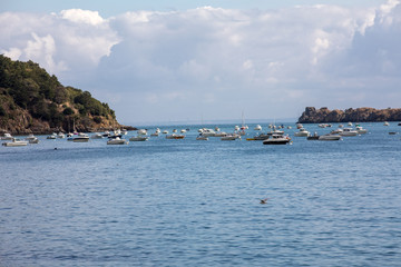 Fototapeta premium Fishing boats and yachts moored in the bay at high tide in Cancale, famous oysters production town. Brittany, France,
