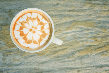 hot cappuccino coffee with cute cream rabbit pattern on wood plate
