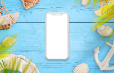 Smart phone concept mockup on blue table surrounded with summer travel symbols, shells and palm leaves.