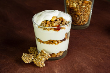 Healthy breakfast with granola and homemade yogurt in a glass. Rustic style