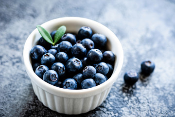Blueberries in a bowl. Freshly picked harvested blueberries in white ceramic bowl, closeup view