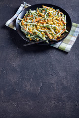 cucumber corn cheese salad on a black plate