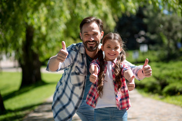 Happy Father And Daughter In City Park Showinh Together Thumb up. Happy Loving Family Concept.