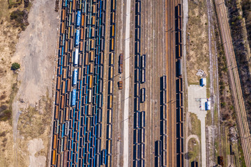 Obraz premium Cargo trains. Aerial view of colorful freight trains on the railway station. Wagons with goods on railroad.Aerial view