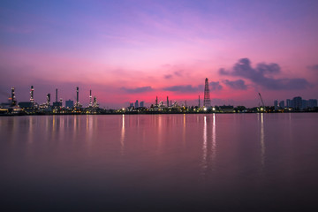 Naklejka premium The blurred background of nature along the river, with views of the cargo ship, oil refinery, sunrise and beautiful sky in the morning