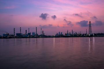Fototapeta na wymiar The blurred background of nature along the river, with views of the cargo ship, oil refinery, sunrise and beautiful sky in the morning