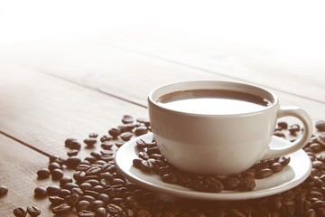 cup of coffee with beans in the morning on wooden table.
