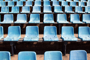 rows of empty blue seats in stadium