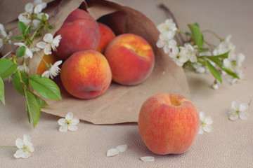 Ripe peaches are poured out of a package made from craft paper.