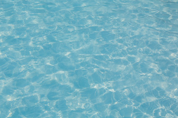 Blue pool water with sun reflection