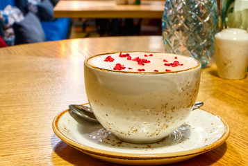 Raspberry Raf coffee in a vegetarian restaurant. Pink coffee based on vegetable milk with dried...
