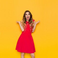 Surprised Beautiful Woman In Red Dress With Arms Outstretched Is Shouting