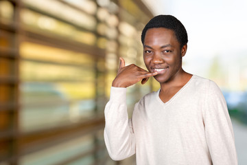Handsome young African man showing a call me sign