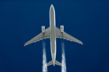 Verkehrsflugzeug mit zwei Turbinen in großer Höhe vor einem dunkelblauen Himmel.