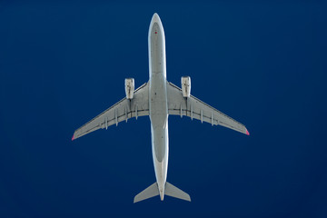 Verkehrsflugzeug mit zwei Turbinen in großer Höhe vor einem dunkelblauen Himmel.