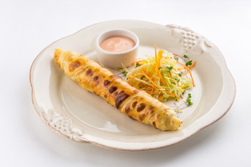 Large sausage roll with carrot cabbage salad isolated on white background