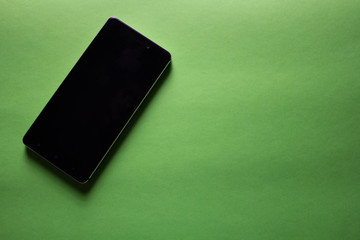 black mockup phone on green background with copy space