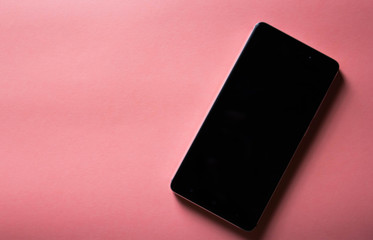 black mockup phone on pink background with copy space