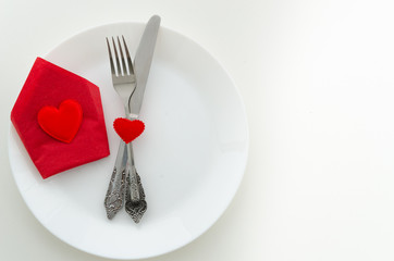 Top view romantic dinner proposal concept. Dish with cutlery and red gift box with heart. Copy space for lettering or your text