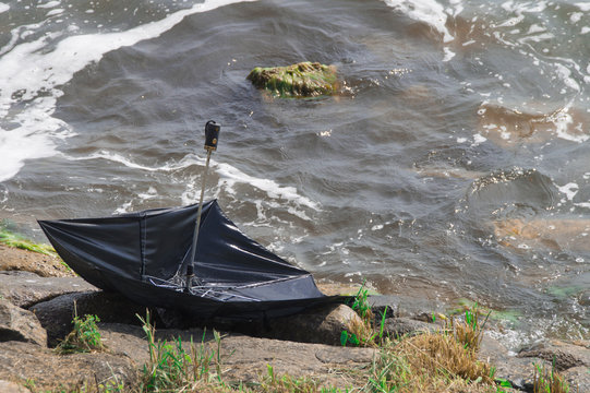 lost broken umbrella on coasline river