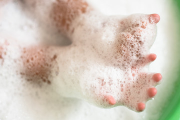 CChild hands in a soap foam bubbles. Concept of hygiene and childhood activities. Selective focus