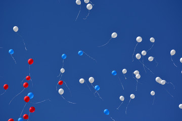 Red, white and blue inflatable balls against the blue sky