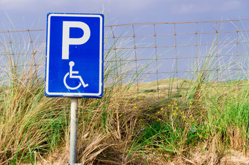 traffic sign parking place for disabled person near the dunes