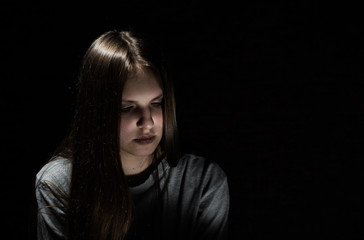 portrait of young teenager brunette girl with long hair in the Gothic style on a black background with copy space