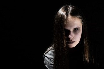 portrait of young teenager brunette girl with long hair in the Gothic style on a black background with copy space