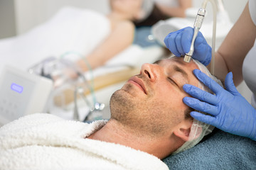 Man receiving cosmetic treatment of face