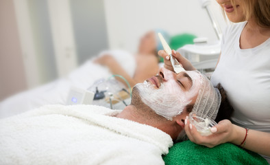 Man receiving hydration facial mask