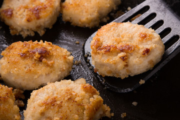 Fried chicken cutlets with a crispy crust in oil, in a pan, close-up. Delicious junk food.