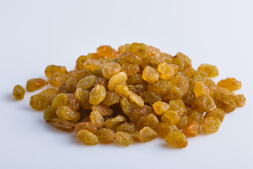 golden raisins on a white acrylic background